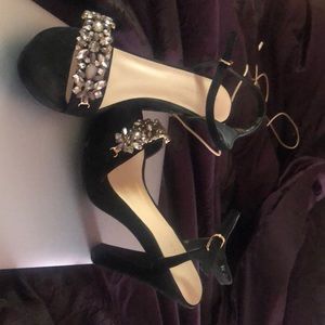 Pair of black heels with rhinestones on front